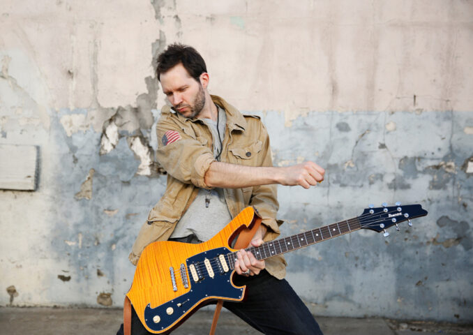 Paul Gilbert playing his Ibanez Iceman guitar.