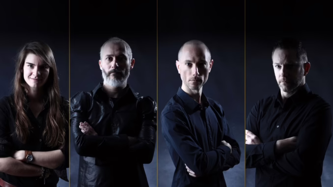 A band portrait of four members standing side-by-side against a dark backdrop, each with their arms crossed.